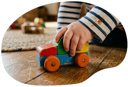 Eine Hand von einem Kleinkind spilet mit einem Auto - dieses Bild wurde durch eine KI erstellt