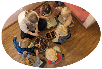 in-Form_Kindergruppe Eine Gruppe von Kindern mit Erzieherin beim Spielen, von oben fotografiert