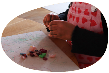 in-Form_Haende Kinderhände spielen mit kleinen Brocken von Knete